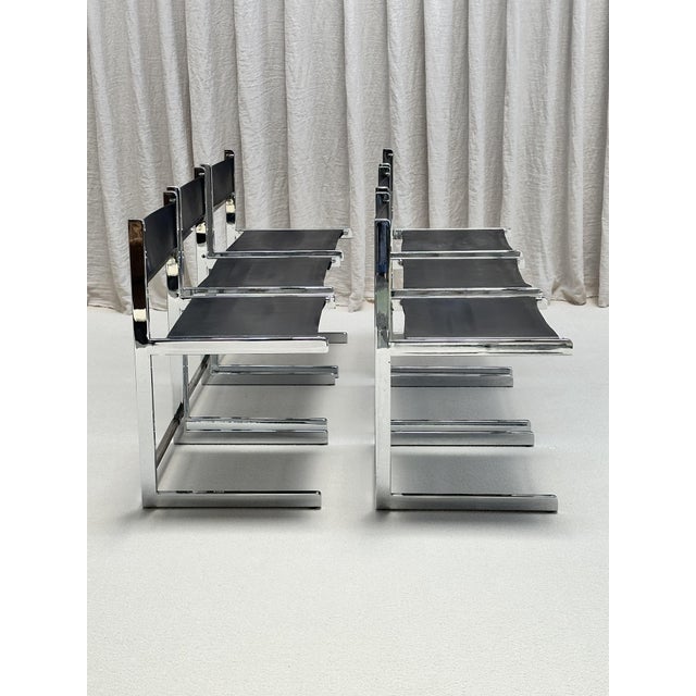 This architectural dining set embodies the fusion of sculptural form and industrial strength. The chairs have a chromed...