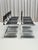 This architectural dining set embodies the fusion of sculptural form and industrial strength. The chairs have a chromed...