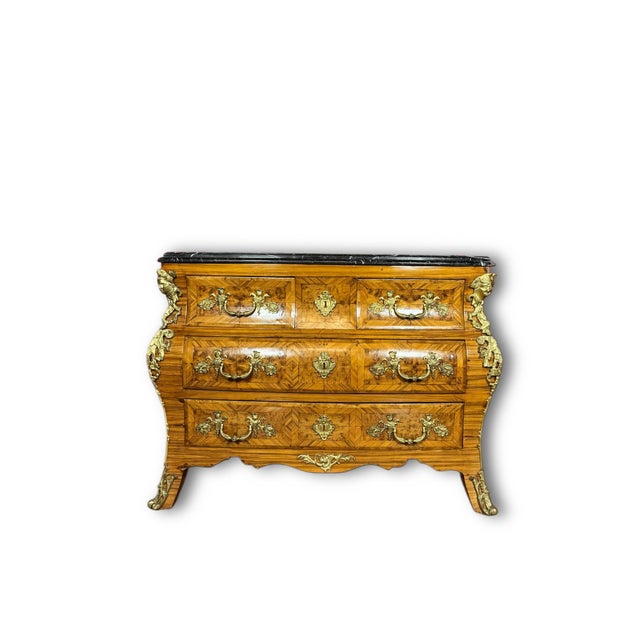 This Louis XV style commode has the full, swelling bombe silhouette of the finest French rococo case pieces. Three long...