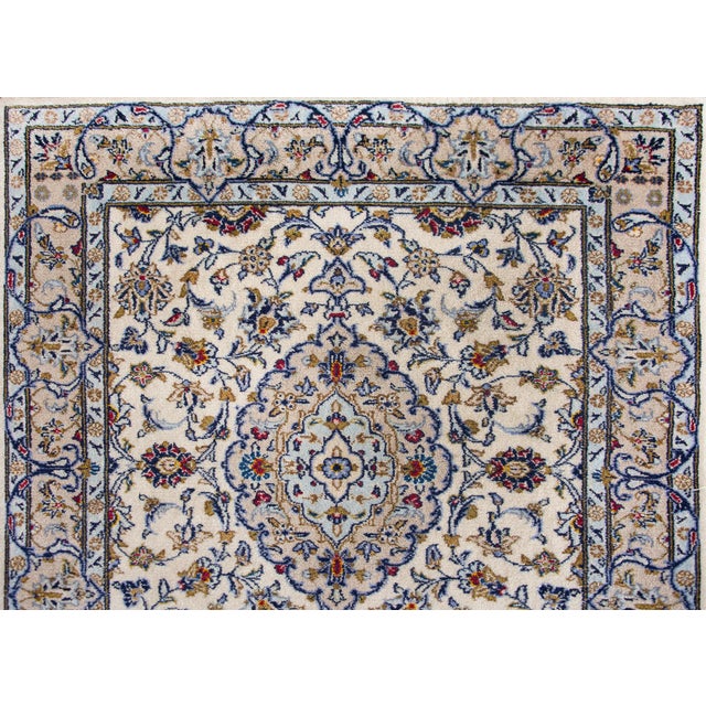 A beautiful mid-20th century Persian Kashan runner with a four large floral medallions living amidst a field of even more...