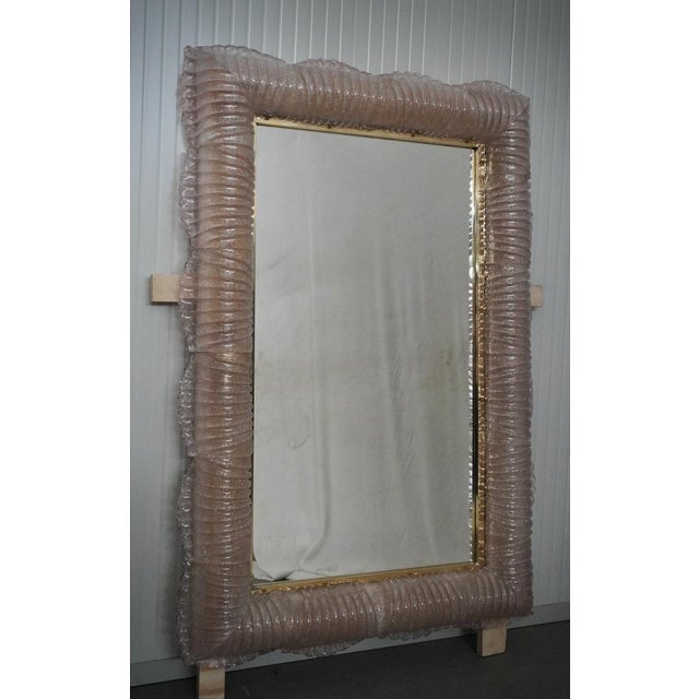 A sturdy pink frame captures the eye of the observer, leaving him enchanted: it is a wall mirror in pink Murano artistic...