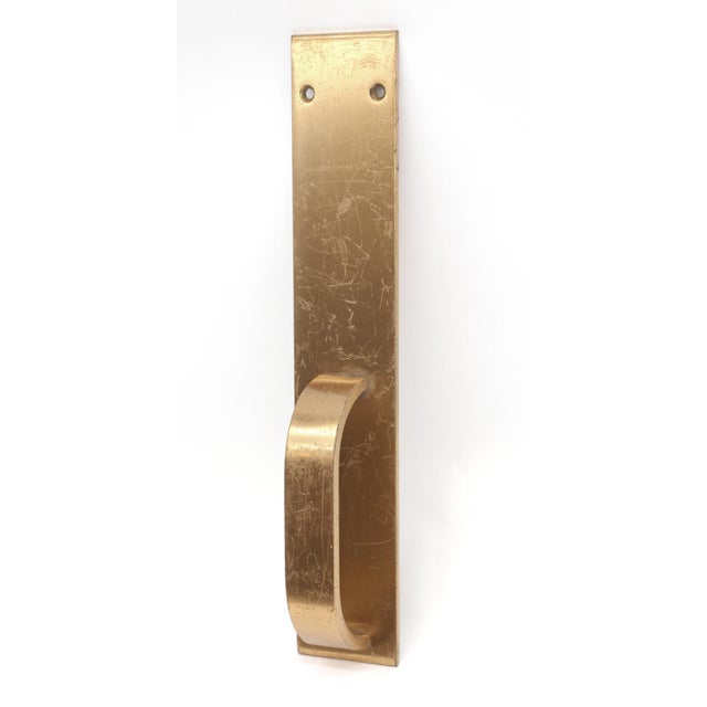 Modern style commercial brass door pull with a bottom centered handle. The original mounting screws are not available. The...