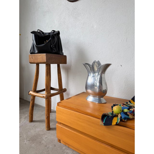 Cast aluminum vase with a generous shape and curved lines, featuring a floral neck. Its curves are handcrafted and...