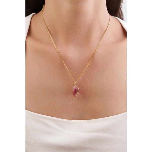 This modern slice pendant showcasing 3.29 carat of natural pink tourmaline, set in 14k yellow gold. The uneven shape that...