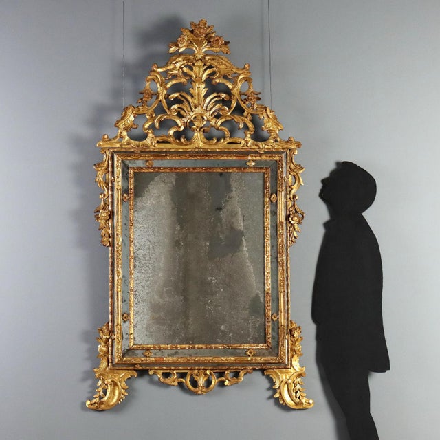 18th-century wall mirror from Piedmont, crafted in carved and gilded linden wood. The rectangular frame houses a mirror...