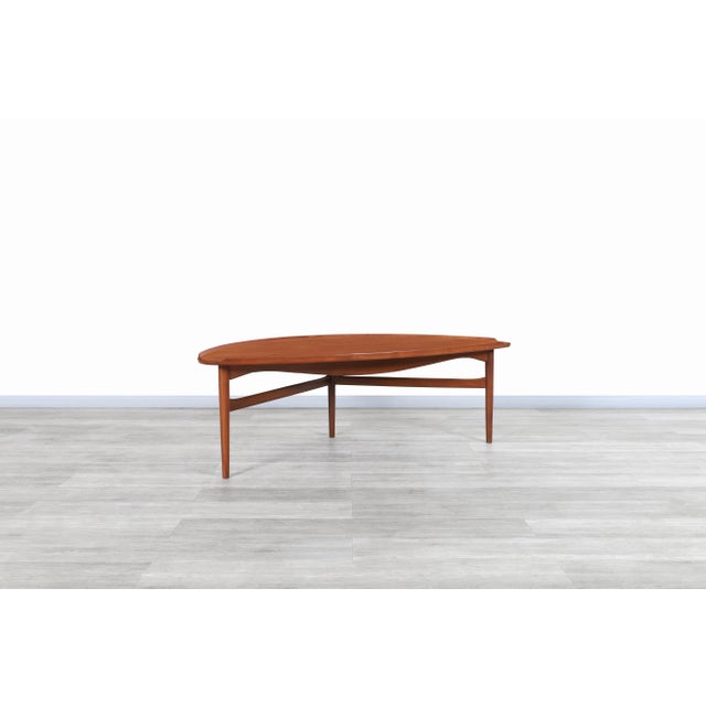 Discover a true icon of Danish modern design with this remarkable coffee table, masterfully crafted by the legendary Finn...