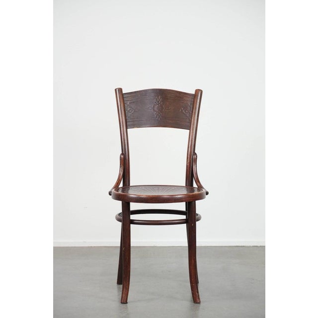 Offered for sale: this timeless vintage wooden Cosmos bistro design chair with beautiful carvings. This wonderful set of...