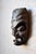 This African mask, carved from a single piece of dense, dark wood, is crafted with remarkable precision and sensitivity....