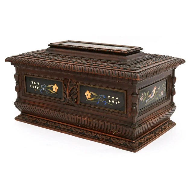Our carved walnut chest from the third or fourth quarter of the nineteenth century features fine pietra dura plaques...
