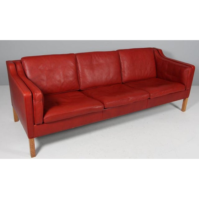 Børge Mogensen three-seat sofa with original red leather upholstery. Legs of oak. Model 2213, made by Fredericia...