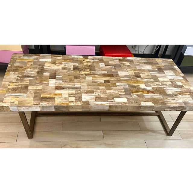 This Marina Home petrified wood coffee table features a striking vein-cut top made from natural fossilized wood in warm,...