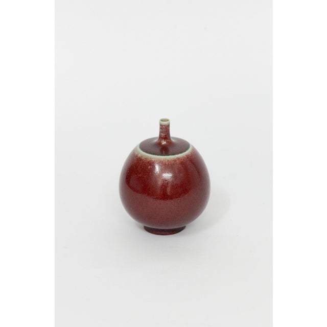The small vase with an oxblood glaze was created for Gustavsberg by the Swedish ceramic artist Berndt Friberg. It is in...