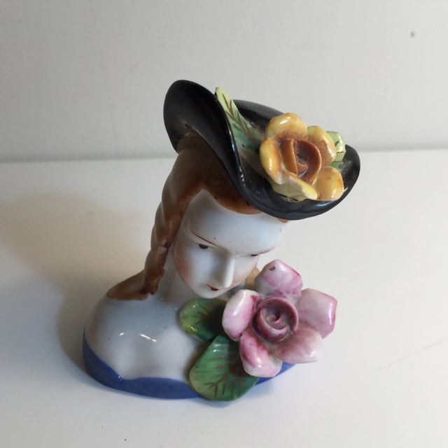 Hand-painted in Japan, marked. Delicate floral motif with a big hat. A shelf sitter.