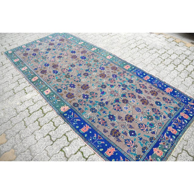 This is a vintage Turkish Oushak rug from the 1960s. The piece was hand-knotted.