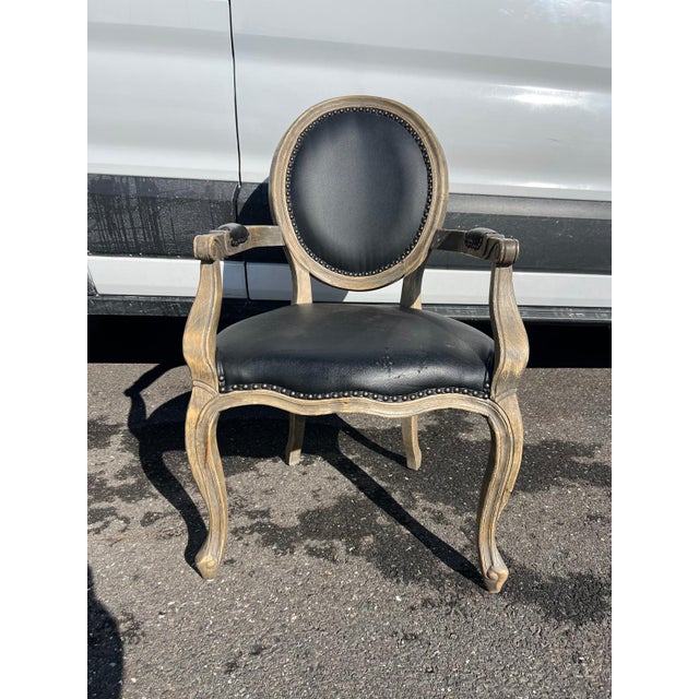 This elegant black leather balloon-back armchair is upholstered in smooth black leather and features a classic oval...