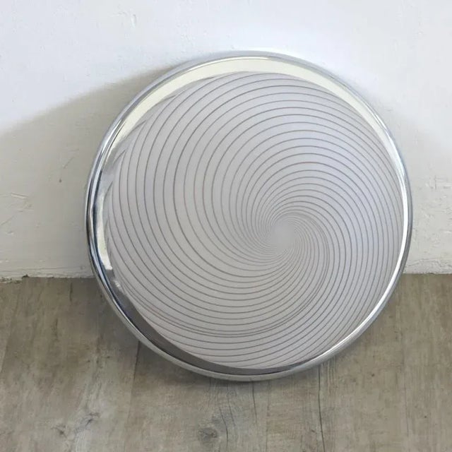 This round ceiling light was made in Italy. It is made from chromed metal and glass which features a spiral pattern....