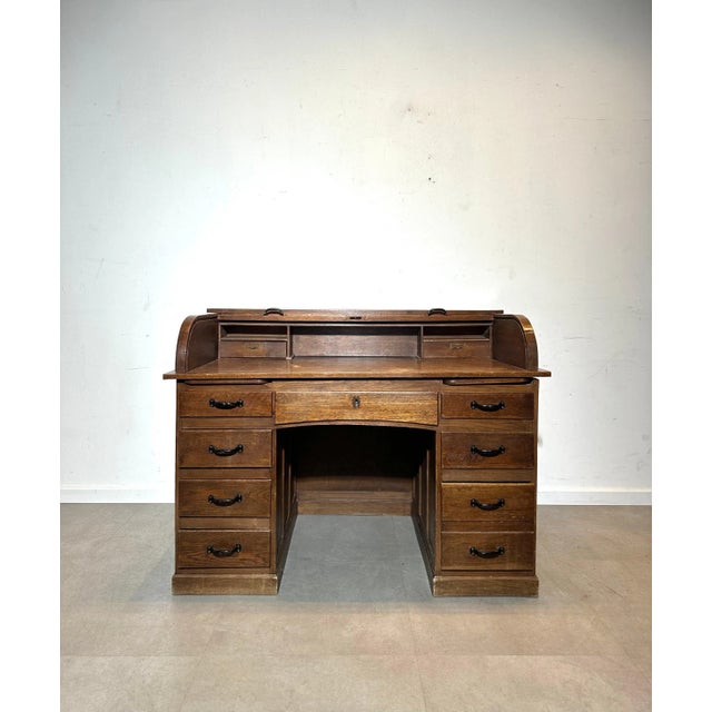 Elegant antique roll-top desk crafted from solid oak, featuring beautiful curved sides and abundant storage. The desk...