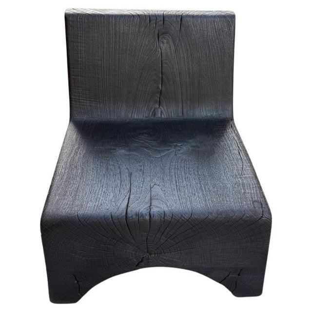 Impressive minimalist chair hand made from century old teak wood. Carved from two blocks of thick wood with an arch on the...