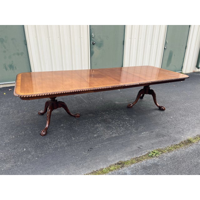 Stunning banded mahogany dining table in a Chippendale and Georgian style from the mid-late 1900's. Solid mahogany...