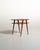 Lightweight, two-tier structure with teak tops and slender, slanted mahogany legs, punctuated by exposed screw joints....