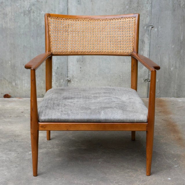 The warm brown color of this chair’s slender frame beautifully complements the cool gray upholstery of the tufted seat....