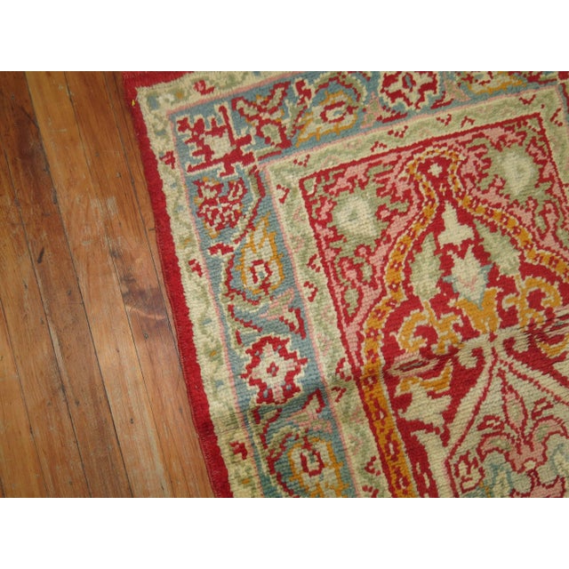 An early 20th century elegant handmade antique Turkish Oushak runner featuring three medallions on a pinkish red field...