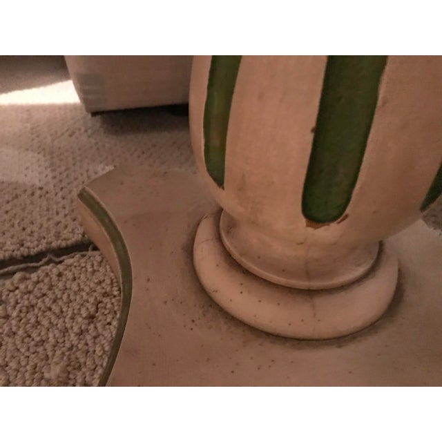 This traditional style console table has a marble top and painted wood base. The carved column two-pedestal base is beige...