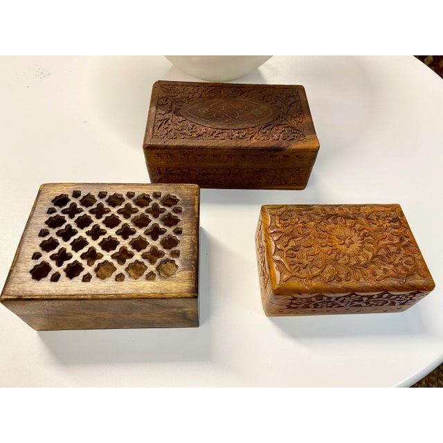 Set of three carved with botanical motif handmade wood boxes. Made in India on underside. Large box is 8”Wx5” D x3” H;...