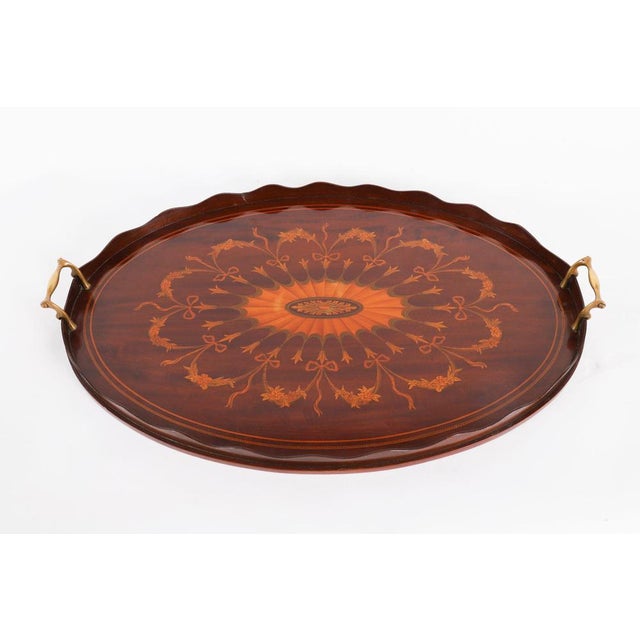 This is a beautiful English Edwardian mahogany and marquetry oval butler's tray, circa 1900 in date. The tray features a...