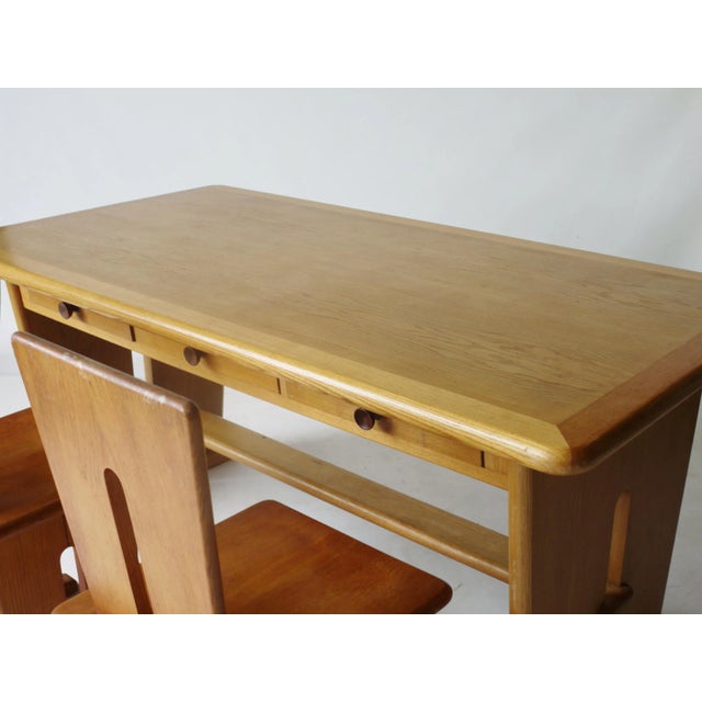 This desk has drawers to both sides. It is brandished with the designers name to the underside. This piece has an...