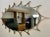Iconic mid-century modern wall mirror. This piece is a large oval wall mirror, with a thick brass sunburst style surround....