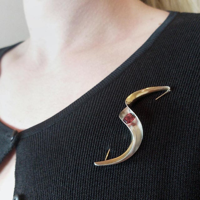 Modernist Silver & Gold Brooch set with 6x8 mm Garnet. In 1996 Gerhard Herbst Studios began exploring ways to incorporate...