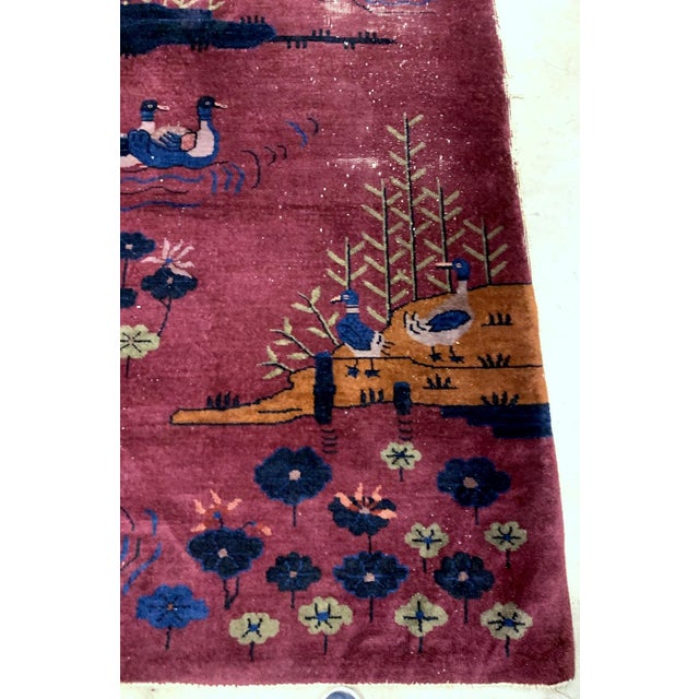 Handmade antique Art Deco Chinese rug in burgundy color with some ducks design. The rug is from the beginning of 20th...