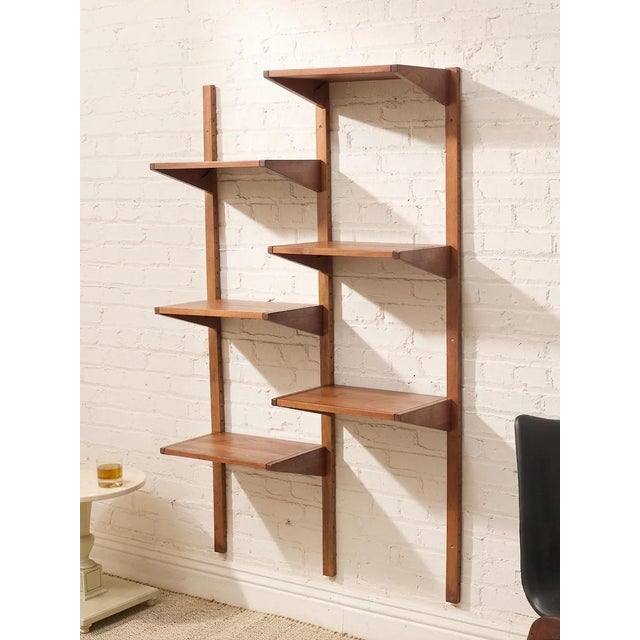 A beautifully restored vintage wall unit with a slim, architectural profile and warm wood finish. Two tall vertical...