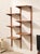 A beautifully restored vintage wall unit with a slim, architectural profile and warm wood finish. Two tall vertical...