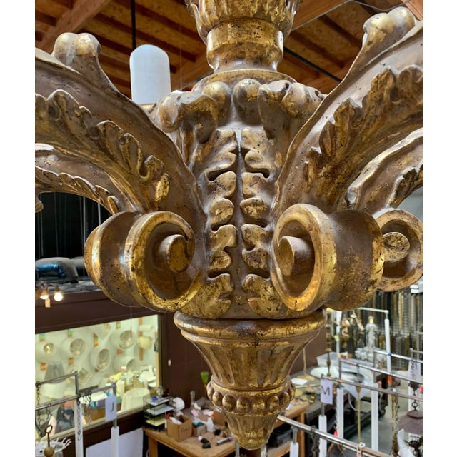 A large baroque style handcarved, gilded Chandelier with wax candle sleeves. This is a wonderful piece for a large Entry.