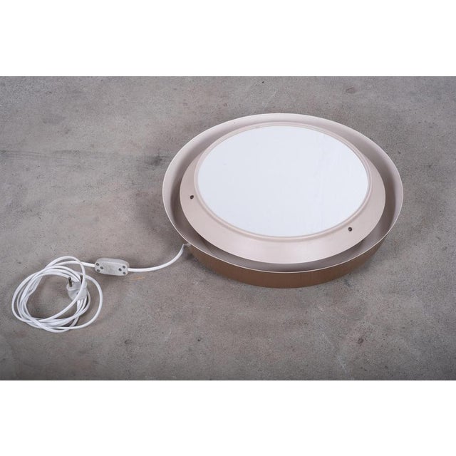 Elegant mirror wall lamp produced by LYFA in Denmark during the 1960s. Featuring a timeless design with a warm brown-toned...