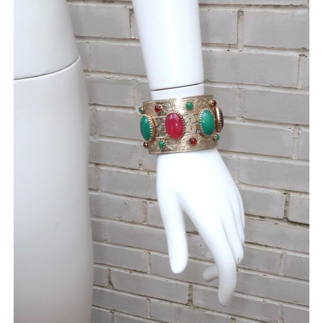 Funky chunky! Mid 20th Century gold finish metal cuff bracelet with an Asian style motif and faux cabochon stones that...