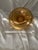 Vintage amber glass serving bowl featuring richly detailed gold gilt decoration. The wide, shallow form is accented by...