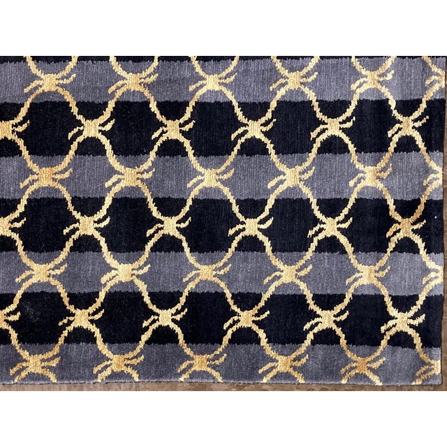 Hand-knotted Nepal wool rug featuring an all-over geometric lattice pattern set on a dark ground with subtle tonal...