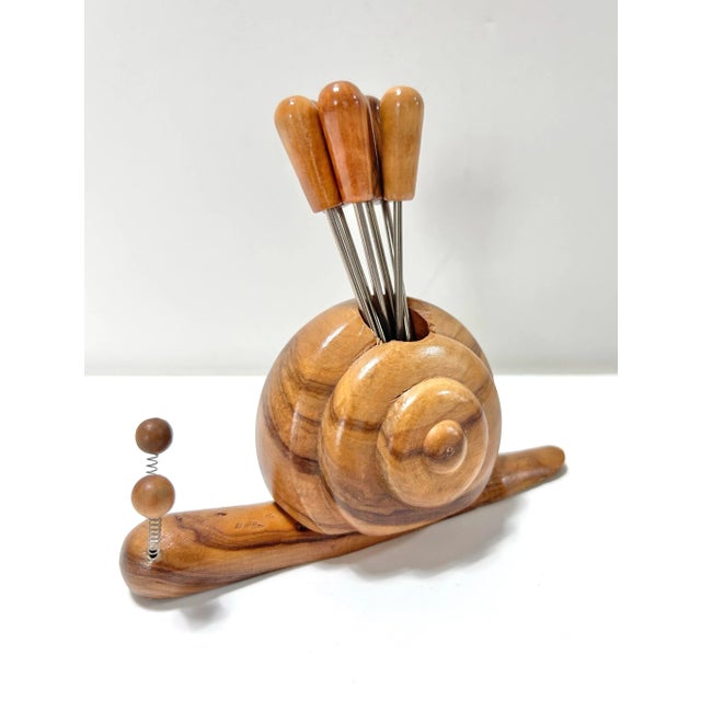 A charming mid-century cocktail pick set featuring a whimsical carved wood snail holder with six matching hors d’oeuvres...
