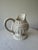 A charming vintage creamware pitcher standing 8" tall. This footed jug features layered embossed relief decoration...