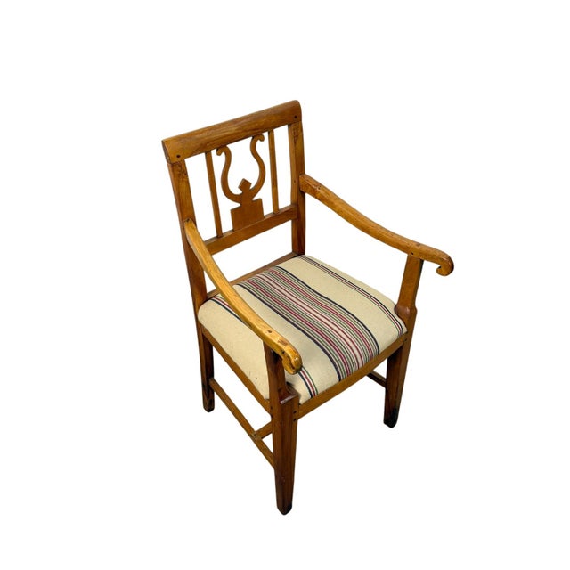 Elegant Dutch Empire armchair crafted in solid cherrywood, featuring a distinctive lyre-shaped back splat and gracefully...