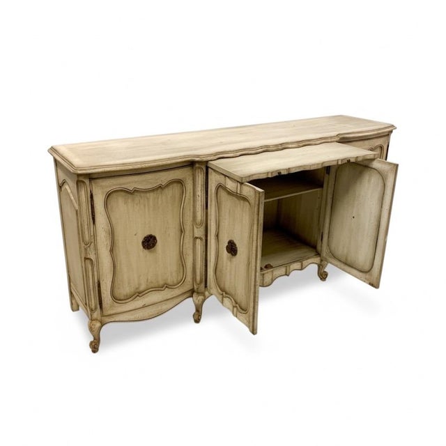 This is a mid-century French Louis XV style credenza or sideboard with a pull out serving surface. It was hand hewn piece...