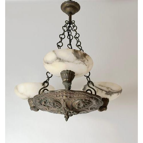 An exceptionally charismatic Renaissance Revival chandelier, circa 1900, combining substantial cast bronze with three...