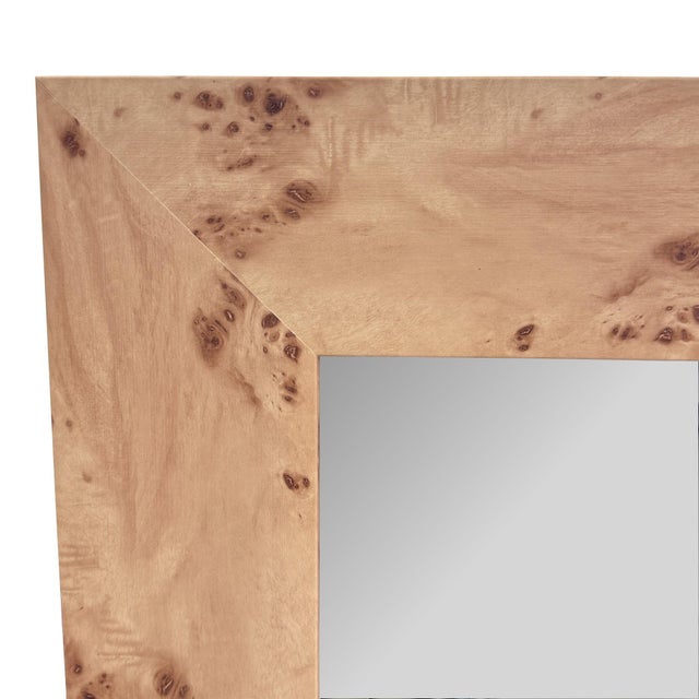 This mirror features a natural wood frame with subtle burl detailing, adding organic texture and warmth to any space....