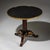 Mahogany Guéridon with a round top in black stone, framed by a profiled brass edge. The fluted column stands on a...