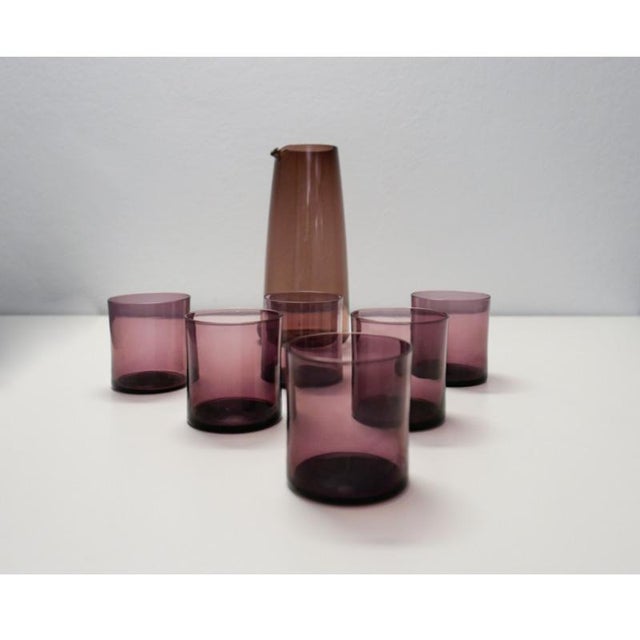 This elegant set of 6 drink glasses and 1 water carafe is made of smoked glass in a beautiful purple amethyst colour. The...