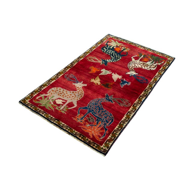 An expressive hand-knotted Gabbeh nomad rug, featuring colorful deer, bird, and plant motifs that create a fairytale...
