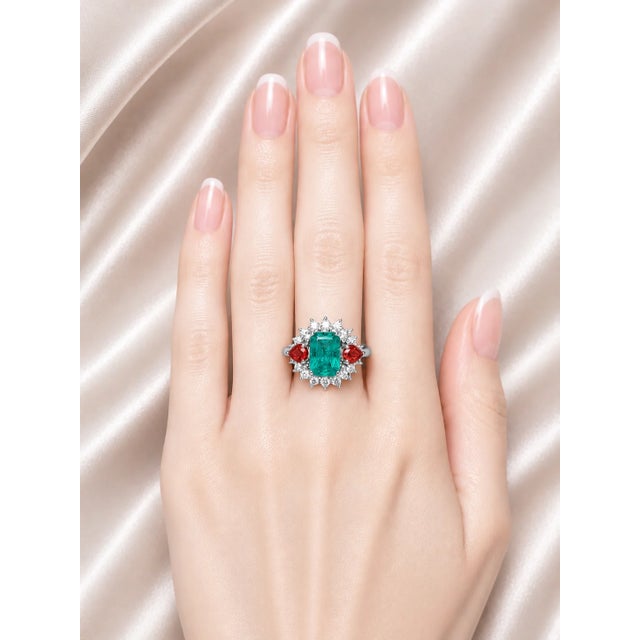 Elegant 18K white gold designer statement ring featuring a 7 carat natural emerald center, accented by 14 brilliant round...